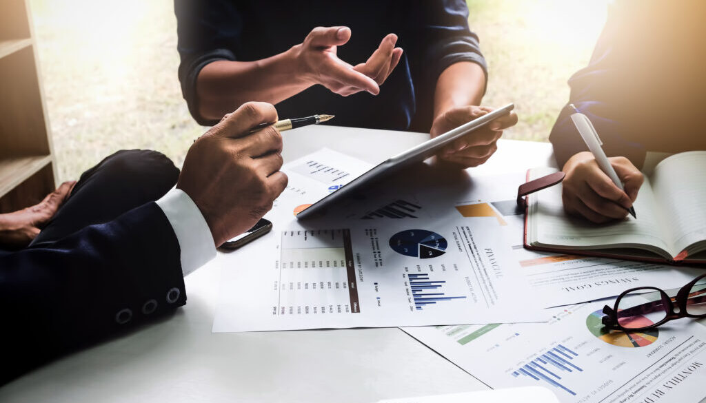 Business people using pen,tablet,notebook are planning a marketing plan to improve the quality of their sales in the future.